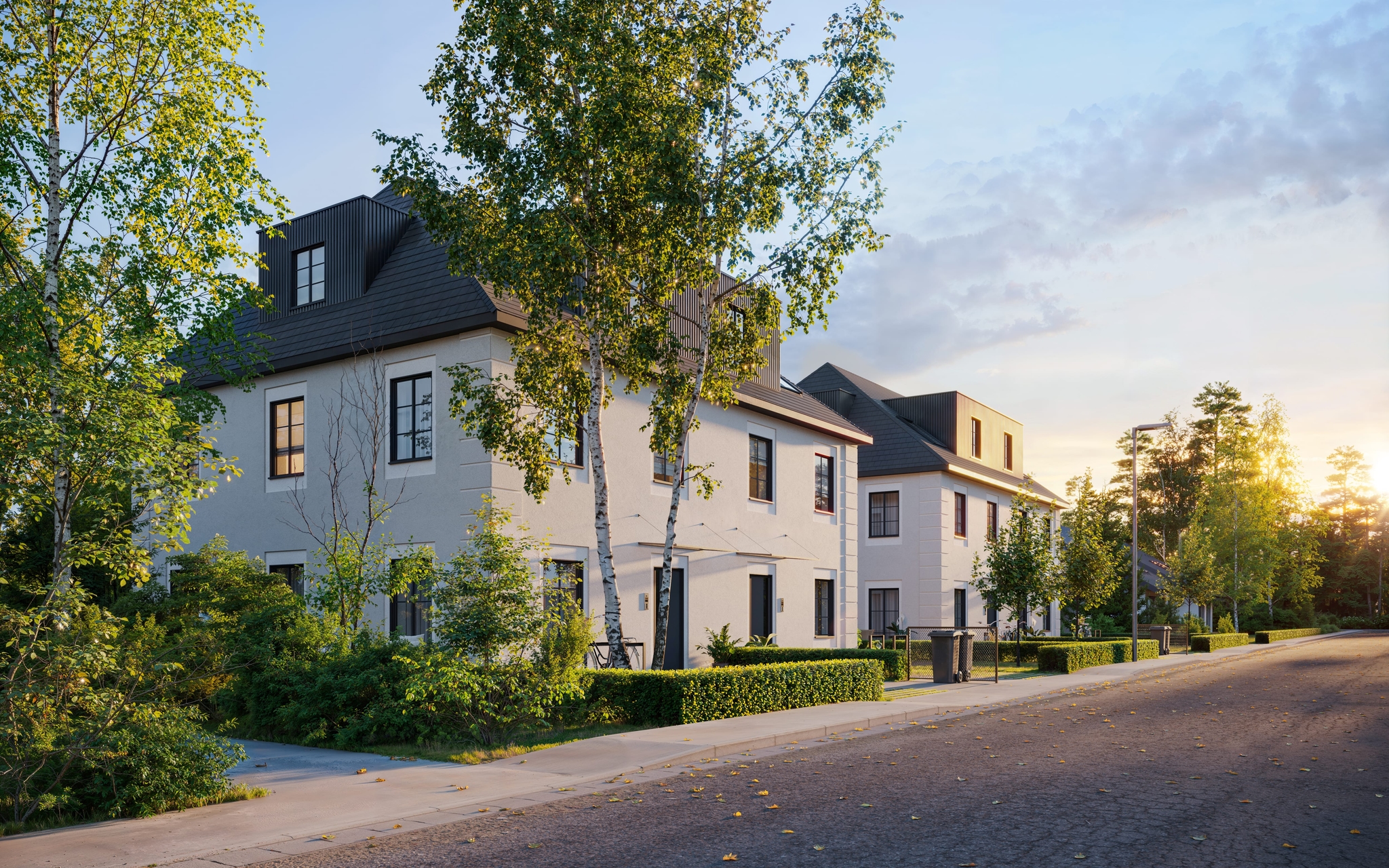 Evening-angle exterior view of residential buildings with natural landscaping, sidewalk lighting, and warm light glowing from inside. Evening-angle exterior view of residential buildings with natural landscaping, sidewalk lighting, and warm light glowing from inside.